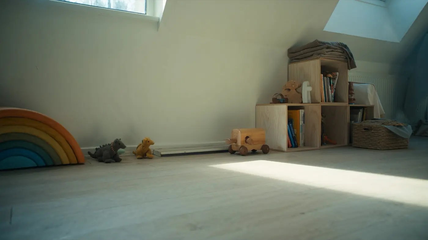 Dachzimmer mit Holzregenbogen, Regal und Spielzeug auf dem Boden